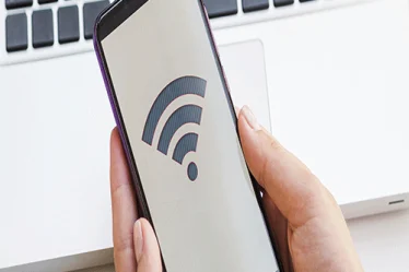 mão segurando celular com símbolo de conexão e senha de wi-fi