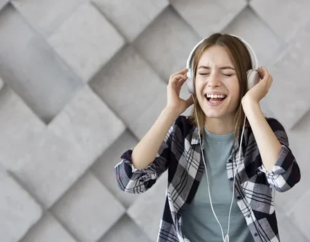 Mulher sorri usa o celular para ouvir música