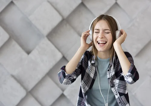 Mulher sorri usa o celular para ouvir música